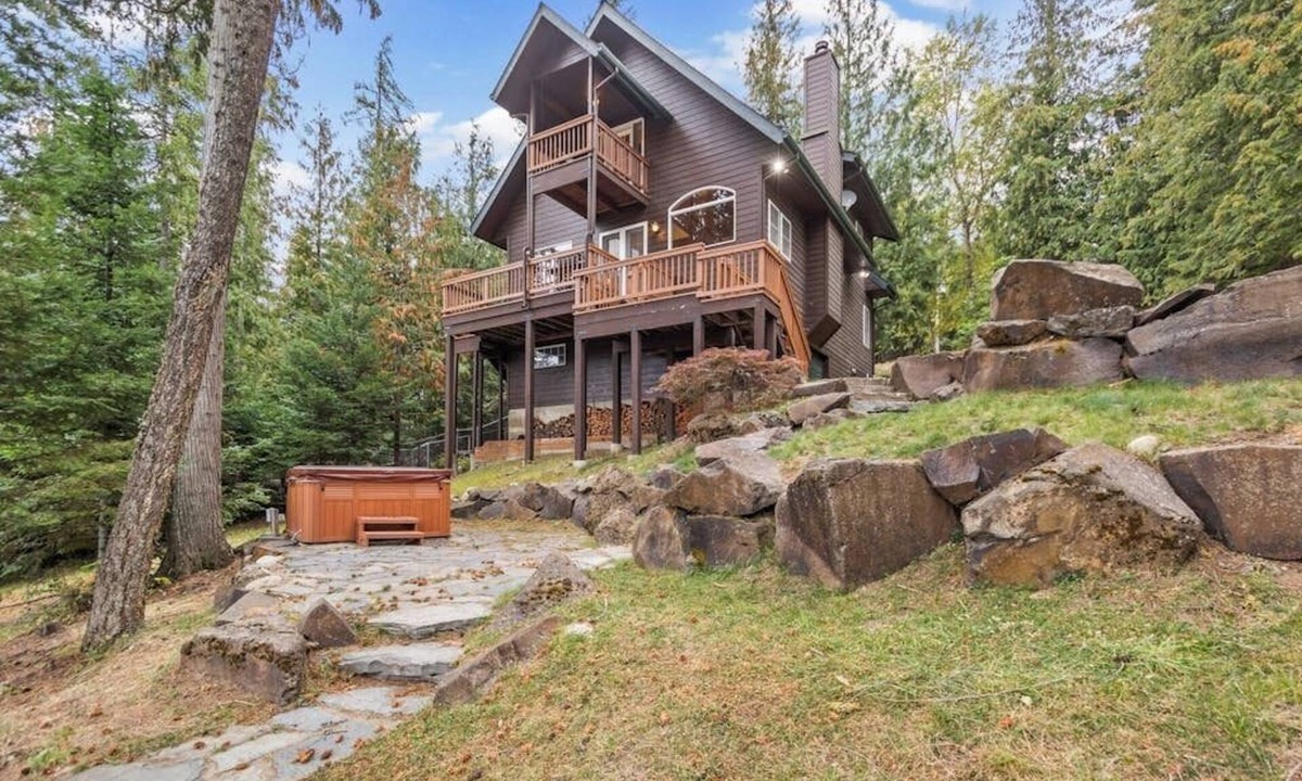 Sandpoint Cabin | Riverfront home with mountain view, hot tub, deck, WiFi, W/D, & fireplace