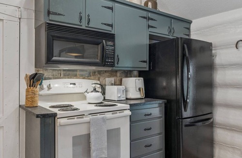 Central Oklahoma City Cabin | 3BR log cabin west OKC — fenced yard, grill, patio. Full kitchen. Sleeps 10. #MW