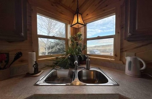 Saddlestring Cabin | Quintessential Wyoming log cabin retreat near Bighorn National Forest, Lake DeSmet, Buffalo, Big Horn, and Sheridan. This charming main house comfortably sleeps 6 with a king bed, twin beds, and queen sleeper sofa. Pets welcome.